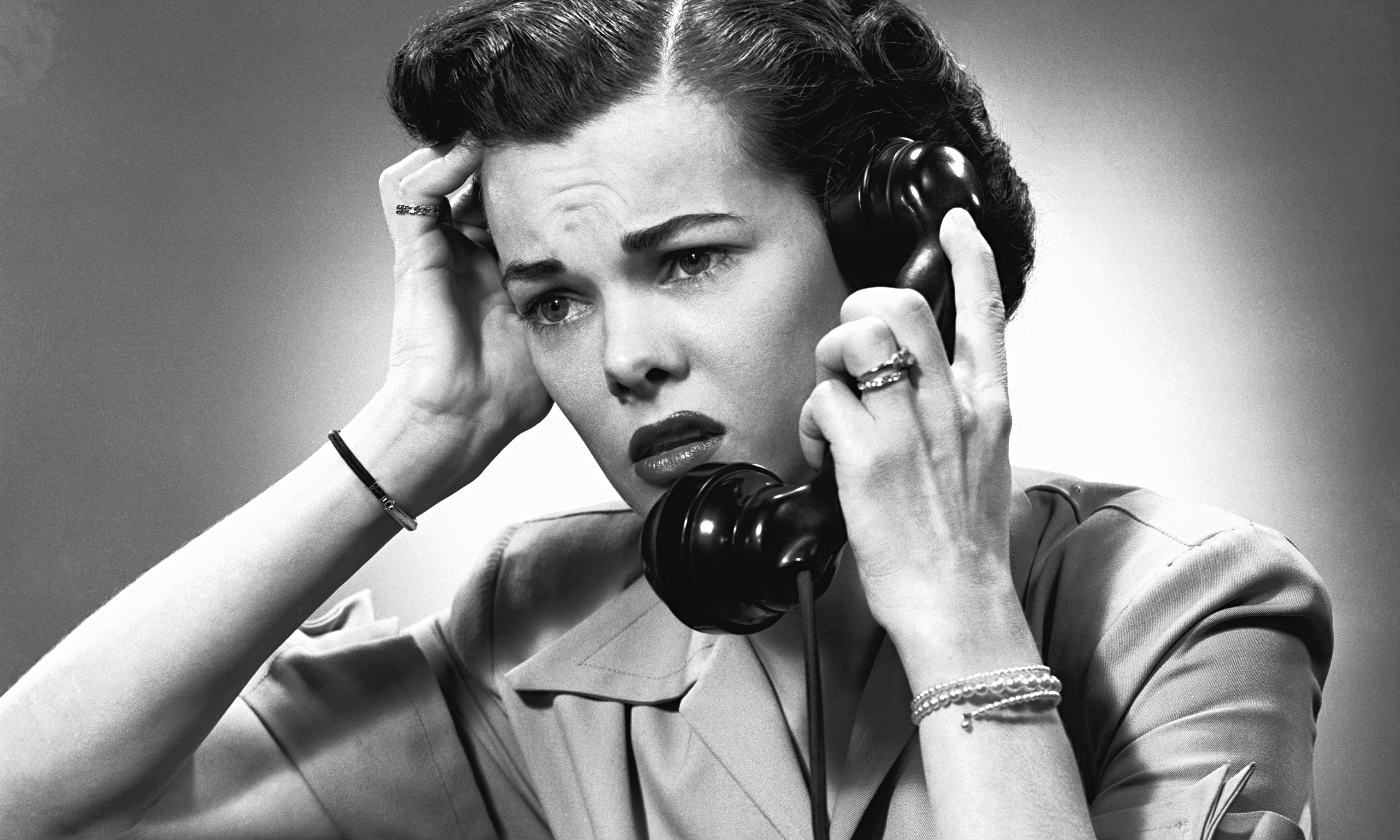 Displeased woman talking on phone in studio, (B&W)