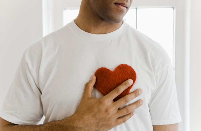 Man holding heart shape on chest