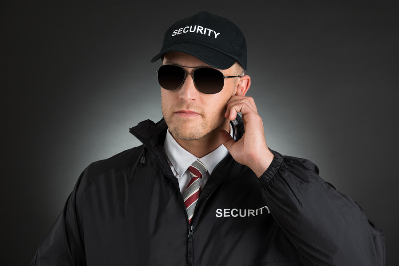 Secret Service Agent Listening To Earpiece Over Black Background