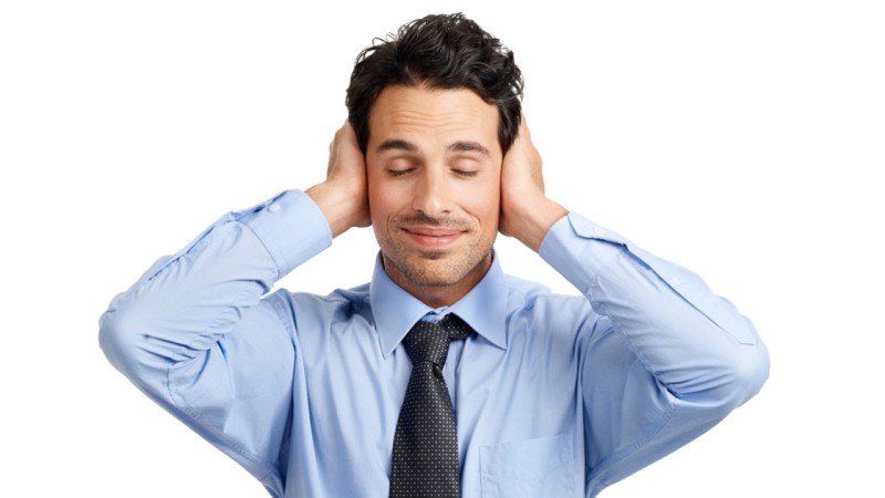 Young businessman looking placid while covering his ears